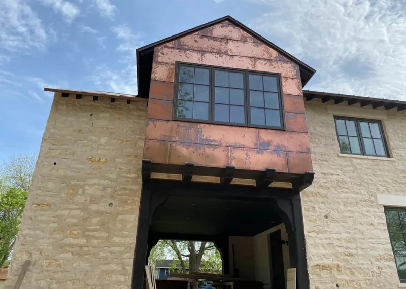 Copper metal panel facade on a stone building for Roof Repair in Crockett