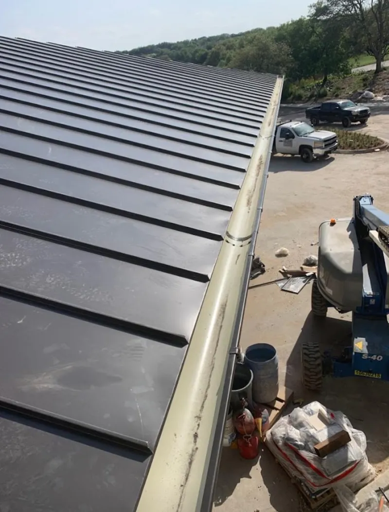 Standing seam panel and gutter detail on a metal roofing jobsite in Crockett